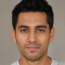 Joyful latino young-adult male with short  black hair and brown eyes