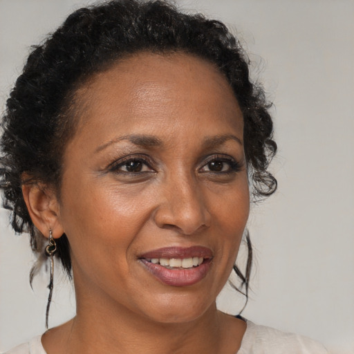Joyful black adult female with medium  brown hair and brown eyes