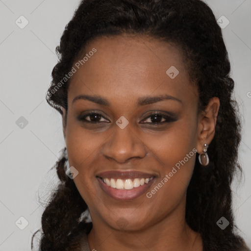 Joyful black young-adult female with long  brown hair and brown eyes