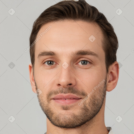 Joyful white young-adult male with short  brown hair and grey eyes