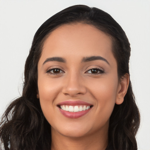 Joyful latino young-adult female with long  brown hair and brown eyes