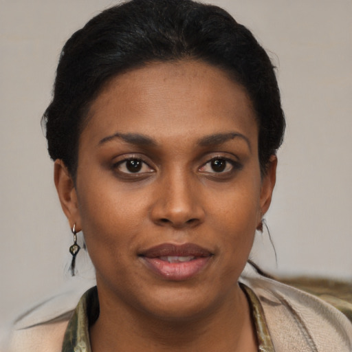 Joyful black young-adult female with short  black hair and brown eyes