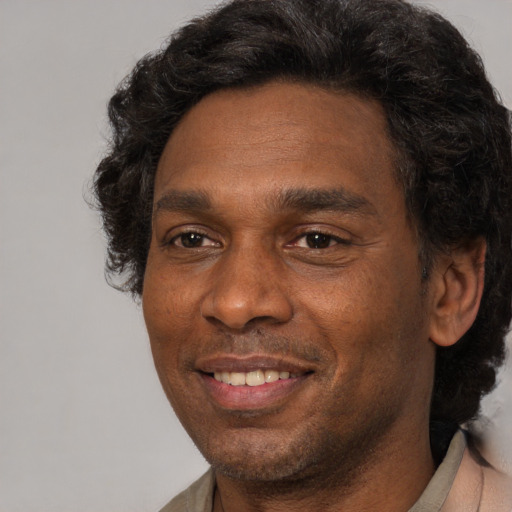 Joyful black adult male with short  black hair and brown eyes