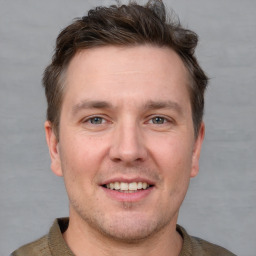 Joyful white adult male with short  brown hair and grey eyes