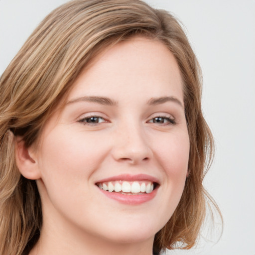 Joyful white young-adult female with medium  brown hair and blue eyes