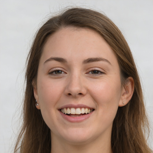 Joyful white young-adult female with long  brown hair and grey eyes