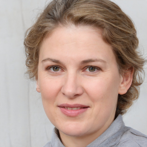 Joyful white adult female with medium  brown hair and blue eyes