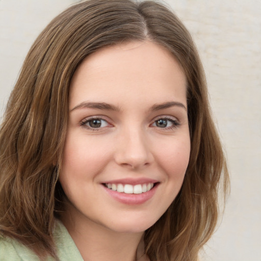 Joyful white young-adult female with medium  brown hair and green eyes