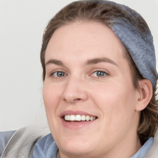 Joyful white young-adult female with short  brown hair and blue eyes