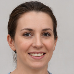 Joyful white young-adult female with medium  brown hair and grey eyes