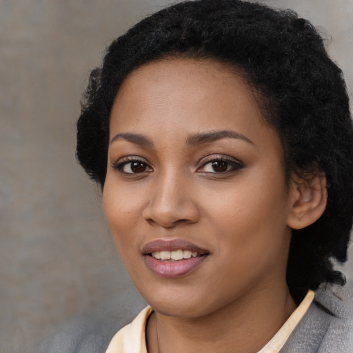 Joyful black young-adult female with medium  black hair and brown eyes