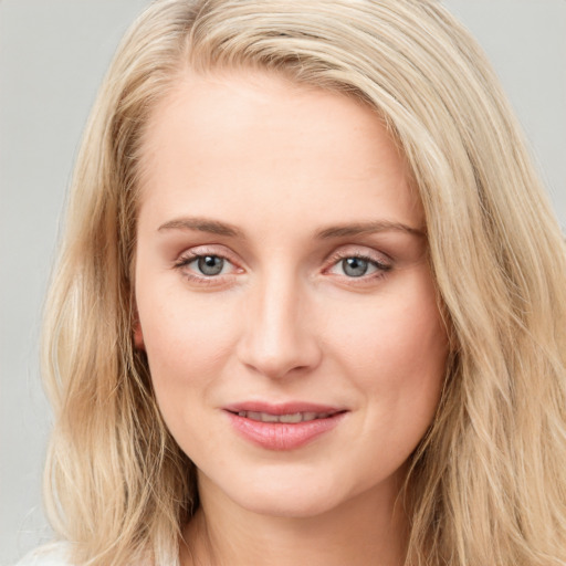 Joyful white young-adult female with long  brown hair and blue eyes