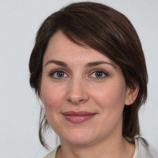 Joyful white young-adult female with medium  brown hair and green eyes