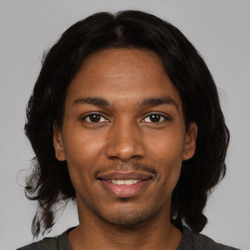 Joyful black young-adult male with medium  black hair and brown eyes