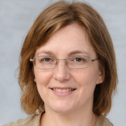 Joyful white adult female with medium  brown hair and blue eyes