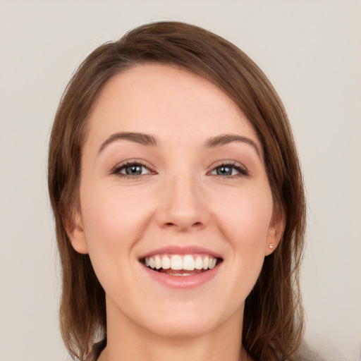 Joyful white young-adult female with long  brown hair and grey eyes