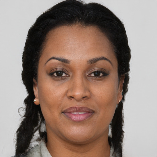 Joyful black adult female with long  brown hair and brown eyes