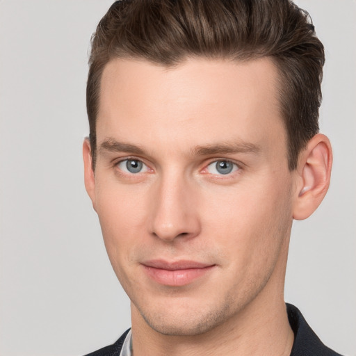 Joyful white young-adult male with short  brown hair and grey eyes