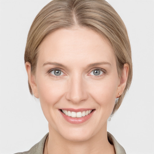 Joyful white young-adult female with medium  brown hair and grey eyes