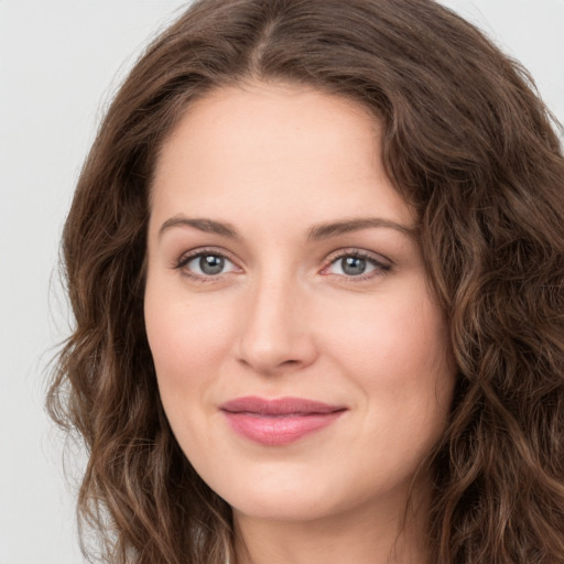 Joyful white young-adult female with long  brown hair and green eyes