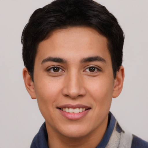 Joyful latino young-adult male with short  brown hair and brown eyes