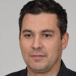 Joyful white adult male with short  black hair and brown eyes