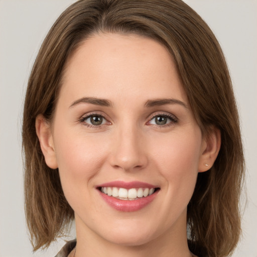 Joyful white young-adult female with long  brown hair and green eyes