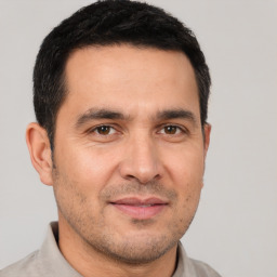 Joyful white adult male with short  black hair and brown eyes