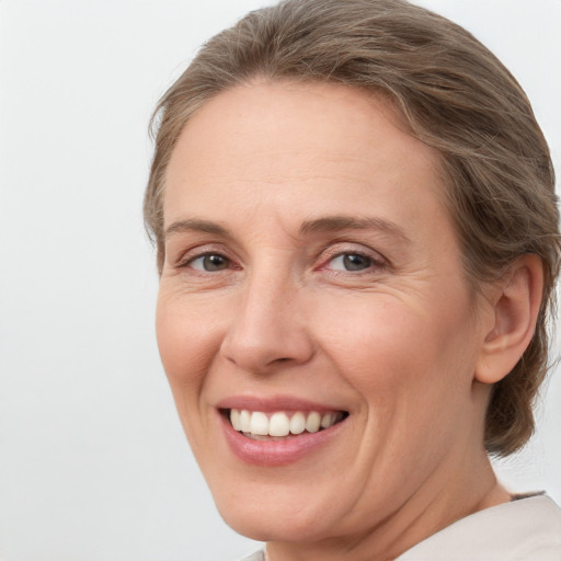 Joyful white adult female with medium  brown hair and grey eyes