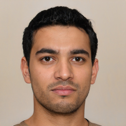 Joyful latino young-adult male with short  black hair and brown eyes