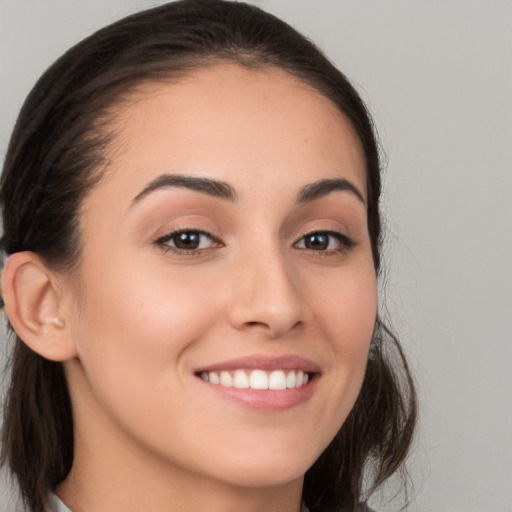 Joyful white young-adult female with long  brown hair and brown eyes