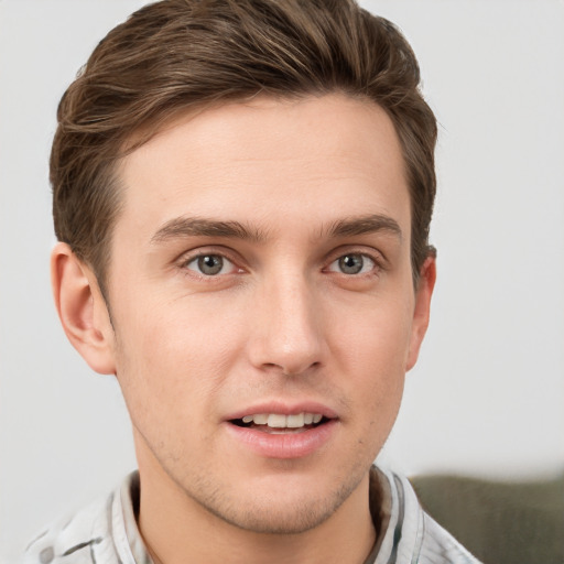 Joyful white young-adult male with short  brown hair and grey eyes