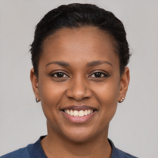 Joyful black young-adult female with short  black hair and brown eyes