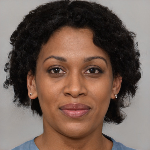 Joyful black adult female with short  brown hair and brown eyes