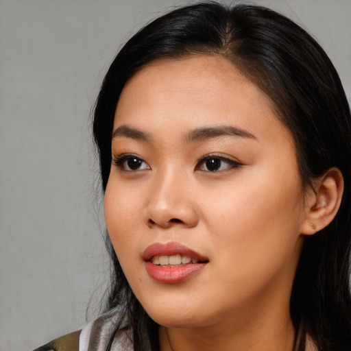 Joyful asian young-adult female with long  brown hair and brown eyes