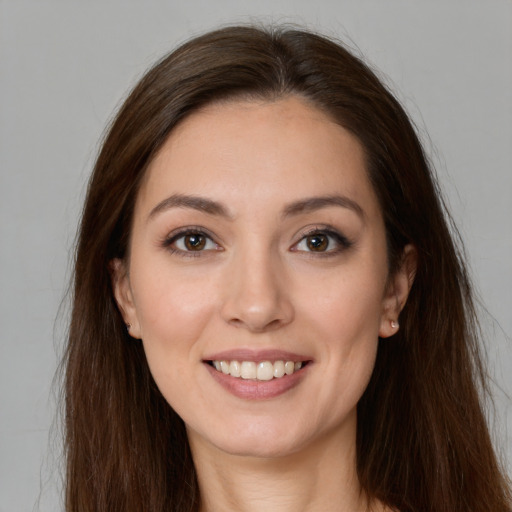 Joyful white young-adult female with long  brown hair and brown eyes