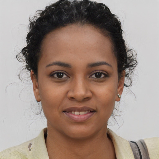 Joyful black young-adult female with short  brown hair and brown eyes