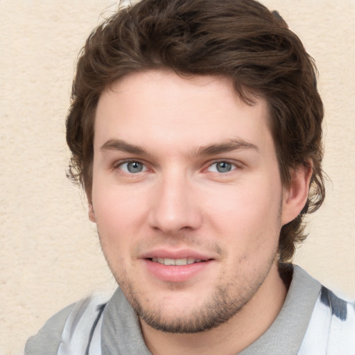 Joyful white young-adult male with short  brown hair and blue eyes