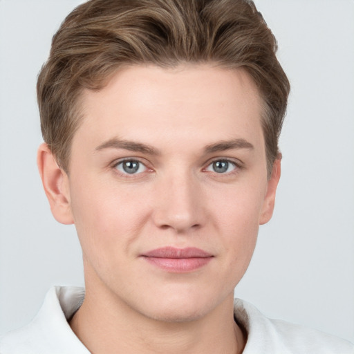 Joyful white young-adult male with short  brown hair and grey eyes