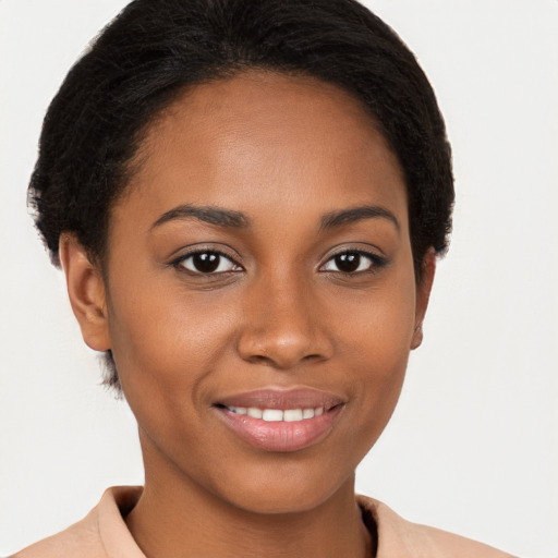 Joyful black young-adult female with short  brown hair and brown eyes