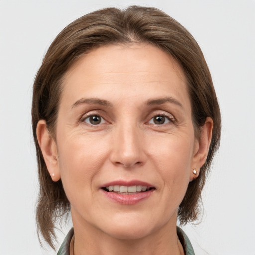 Joyful white adult female with medium  brown hair and grey eyes