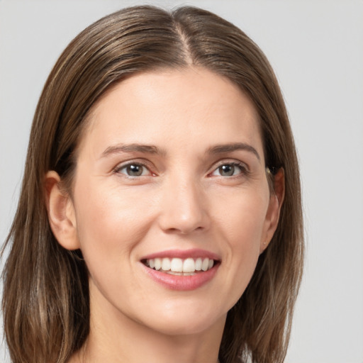 Joyful white young-adult female with long  brown hair and grey eyes