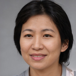 Joyful asian adult female with medium  brown hair and brown eyes