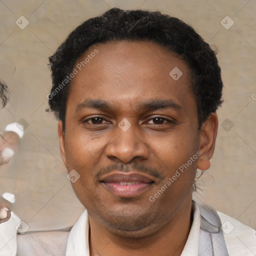 Joyful black adult male with short  black hair and brown eyes