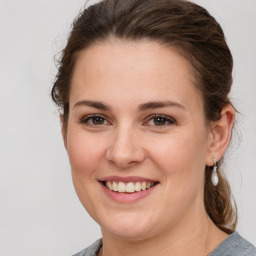 Joyful white young-adult female with medium  brown hair and grey eyes