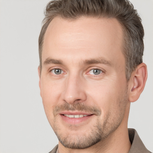 Joyful white adult male with short  brown hair and brown eyes