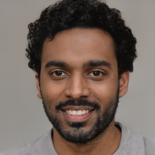 Joyful black young-adult male with short  black hair and brown eyes