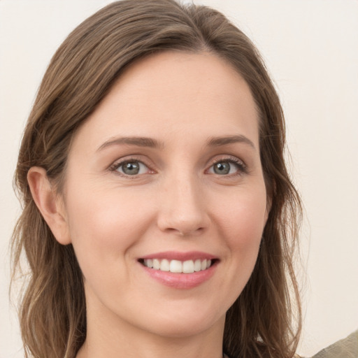 Joyful white young-adult female with long  brown hair and green eyes