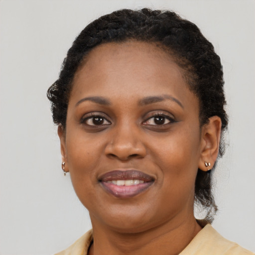 Joyful black young-adult female with short  brown hair and brown eyes