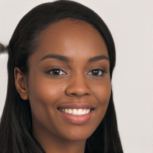 Joyful black young-adult female with long  black hair and brown eyes